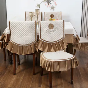 Elegantes Set aus cremefarbenen Stuhlhussen und Tischdecke mit traditioneller Stickerei