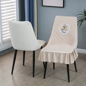 Vue détaillée de la housse de chaise beige en velours avec broderie et jupe à volants