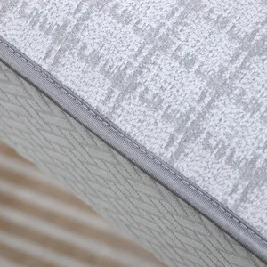 Vue rapprochée des coutures de qualité et du tissu gris texturé d'un coussin de chaise.