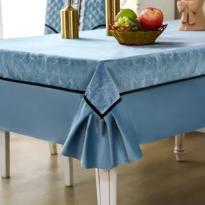 Macro detail of elegant blue textured tablecloth with decorative black corner trim on dining table