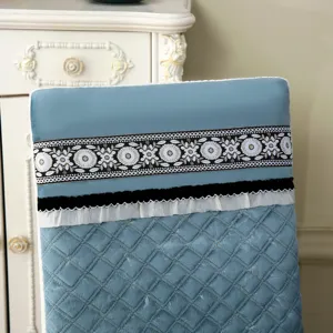 Détail d'une housse de chaise bleue matelassée avec dentelle florale et volants élégants