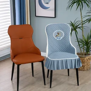 Detail of blue quilted chair cover with lace trim and deer embroidery design