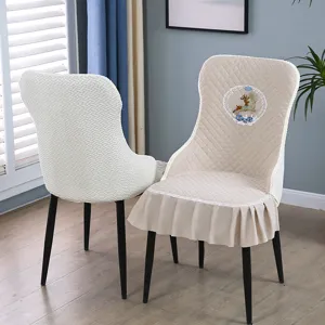 Detail view of quilted chair covers with elegant deer embroidery and ruffled skirt