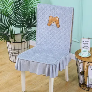 Detail of light blue velvet chair cover with cute bear embroidery and ruffled skirt