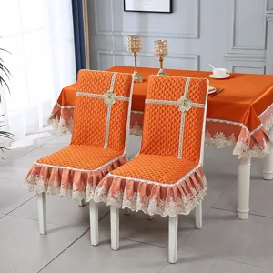 Elegant orange quilted chair covers and matching tablecloth set with intricate lace trim decor