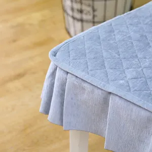 Close-up detail of a blue velvet quilted chair cover featuring an elegant ruffled skirt