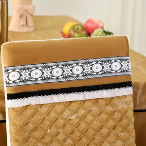 Gros plan d'une housse de chaise dorée matelassée avec dentelle et broderie florale