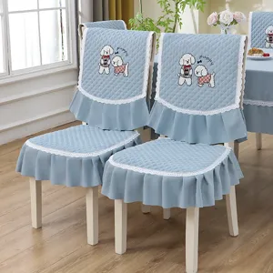 Détail d'une housse de chaise matelassée bleu clair avec dentelle et broderie chiot