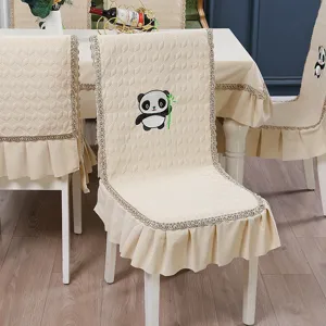 Detail of beige quilted chair cover with cute embroidered panda holding bamboo