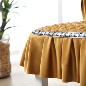 Détail d'une housse de chaise en velours moutarde avec dessus matelassé et volant