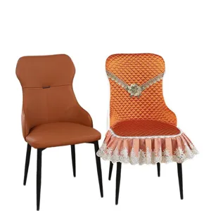 Orange quilted chair cover with lace trim shown on a dining chair, white background