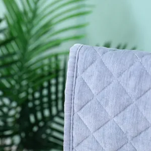 Macro view showing the texture of thick grey velvet quilted chair cover with fine stitching.