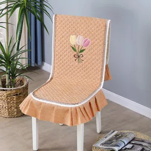 Orange quilted chair cover with tulip embroidery and ruffled skirt for dining chairs