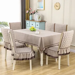 Elegant beige quilted fabric dining table cloth and matching chair cover set with ruffled edges