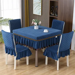 Dettaglio di una tovaglia trapuntata blu scuro e set di coprisedie coordinati per la sala da pranzo