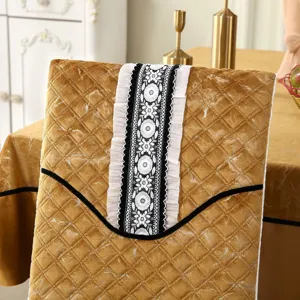 Detail view of quilted gold chair cover featuring elegant floral lace and ruffle accents