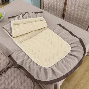 Detail of a quilted dining chair cover with ruffles and elastic securing straps