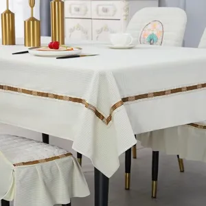 Detailed view of white corduroy tablecloth with elegant gold ribbon trim and ruffles