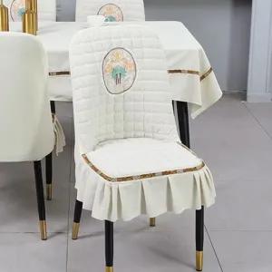 Elegant cream quilted dining chair cover with floral embroidery and ruffled skirt