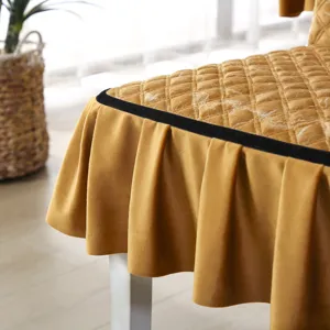 Detail showing the quilted texture and ruffled skirt of the golden velvet chair cover.