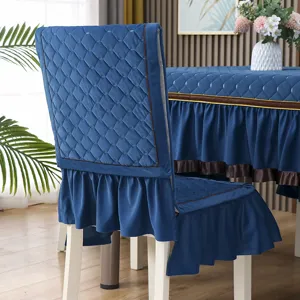 Dettaglio del tessuto trapuntato blu sul coprisedia e sulla tovaglia a balze coordinata.
