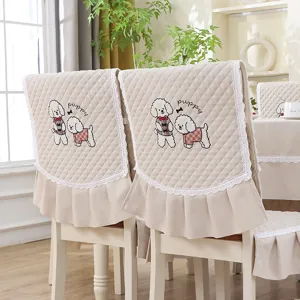 Détail de la housse de chaise beige matelassée avec broderie chiot et bordure dentelle