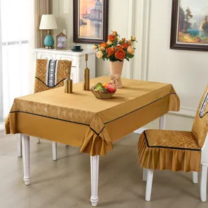 Elegant gold velvet chair covers and matching tablecloth set in a home dining setting.