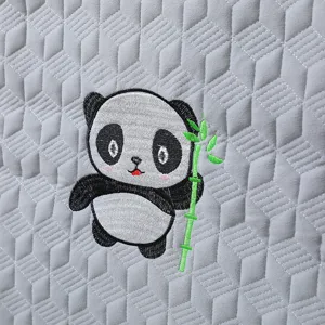 Close-up of gray quilted chair cover with cute cartoon panda embroidery detail