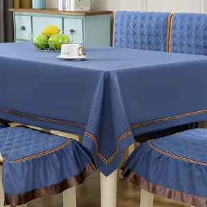 Detail of blue tablecloth and matching quilted chair cover set with decorative trim