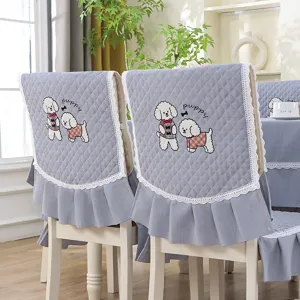 Housse de chaise bleu-gris avec broderie chiot et dentelle dans un décor maison