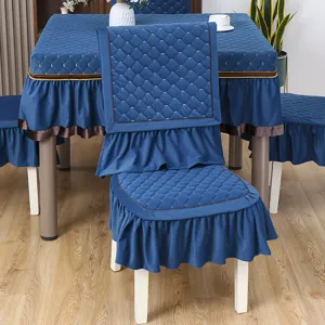 Dettaglio del coprisedia da pranzo blu trapuntato e tovaglia coordinata con volant