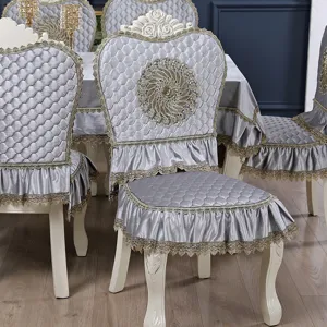 Detailed view of silver European chair covers with elegant gold lace and quilted satin