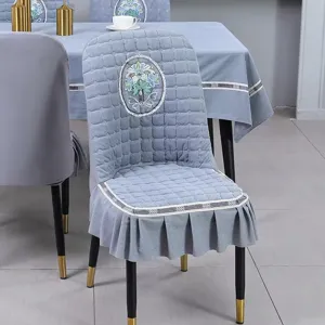 Nordic style blue quilted chair cover with elegant floral embroidery and ruffled skirt.