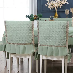 Close-up of sage green quilted chair back covers with elegant lace trim and ruffles