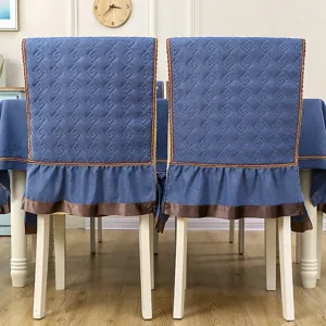 Close-up of blue quilted chair covers with ruffle trim and matching tablecloth