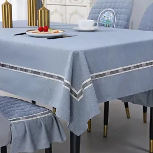 Macro view of light blue textured tablecloth and matching chair covers in a dining room