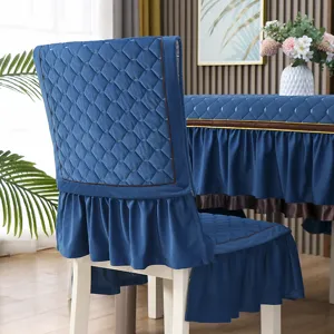 Dettaglio di coprisedia trapuntati blu con volant in un ambiente sala da pranzo