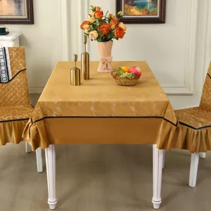 Golden marble pattern dining chair covers and matching tablecloth in elegant home setting.