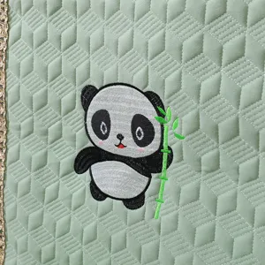 Close-up of cute panda embroidery on green quilted thick chair cover fabric