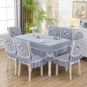 Vue de salle à manger montrant des housses de chaise matelassées grises avec broderie