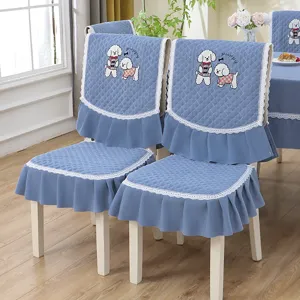 Vue détaillée des housses de chaise bleues matelassées avec broderie chien et dentelle blanche