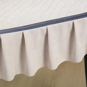 Primo piano di un coprisedia beige con motivo a rombi trapuntati e gonna a pieghe