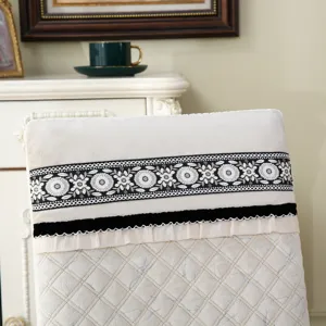 Détail d'une housse de chaise matelassée crème avec dentelle brodée florale élégante