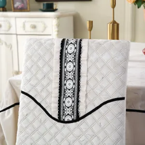 Close-up of quilted chair back cover with elegant black floral embroidery and ruffle details