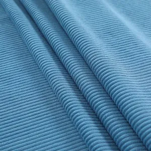 Close-up detail of premium blue ribbed corduroy fabric showing soft stretch texture.