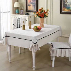 Elegant cream-colored dining chair cover and tablecloth set with black trim detail