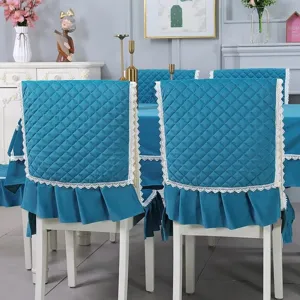 Detailed view of peacock blue quilted dining chair cover with elegant white lace trim