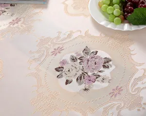 Close-up macro view showing the elegant floral jacquard pattern on a beige fabric tablecloth