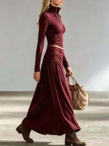 Elegant burgundy half-zip top and low-waist maxi skirt two-piece outfit in motion