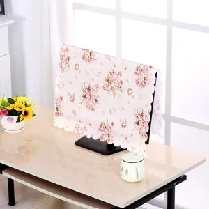 Nahaufnahme von Blumenmuster und Spitzenbesatz an einer Monitor-Staubschutzhülle